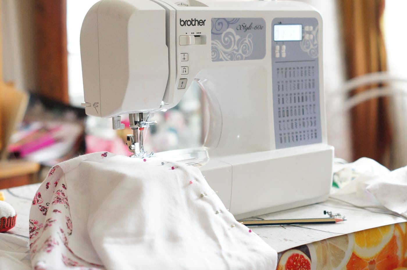 A sewing machine with cloth spread across the table beside it