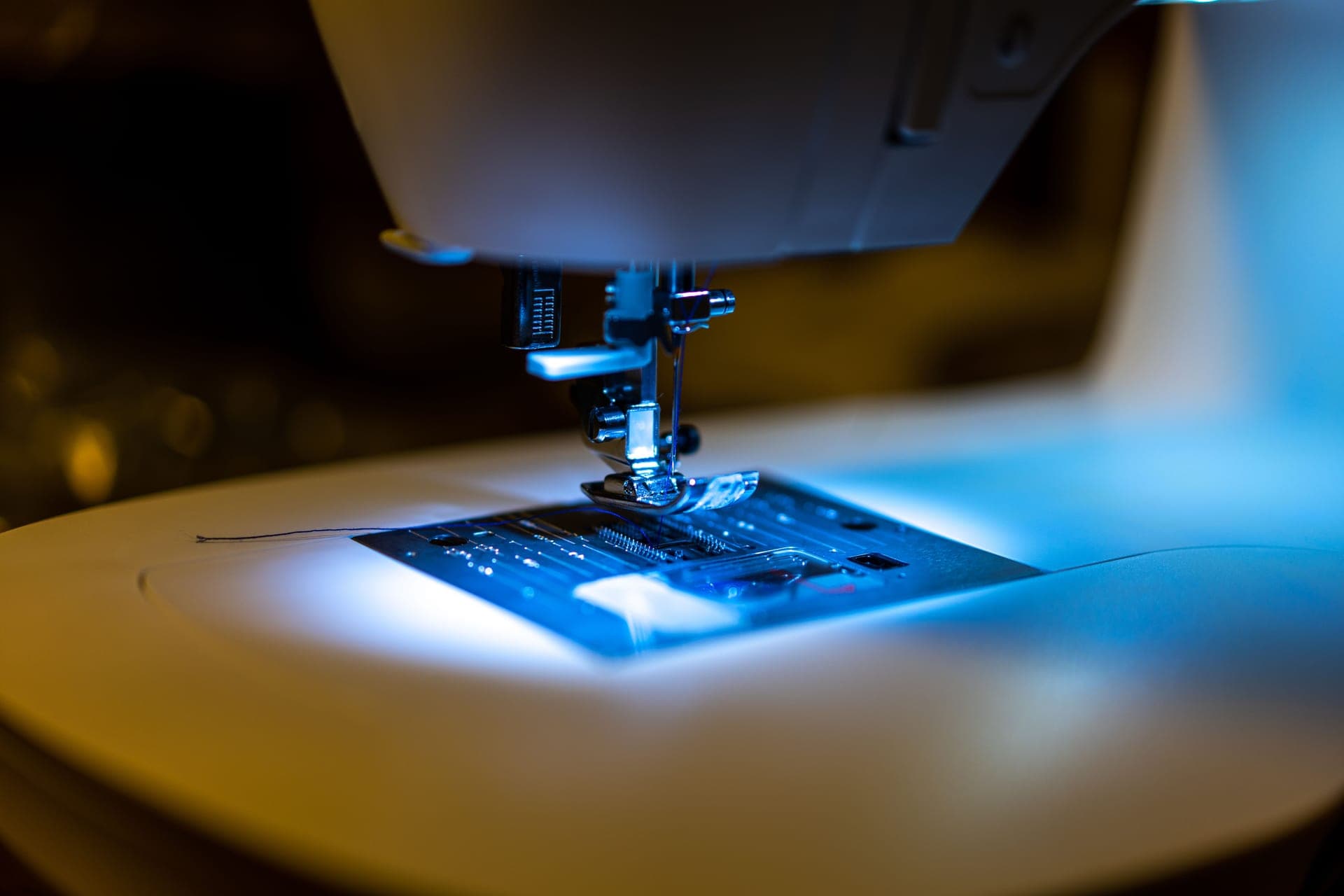 Close view of a sewing machine needle area lit by an LED work light