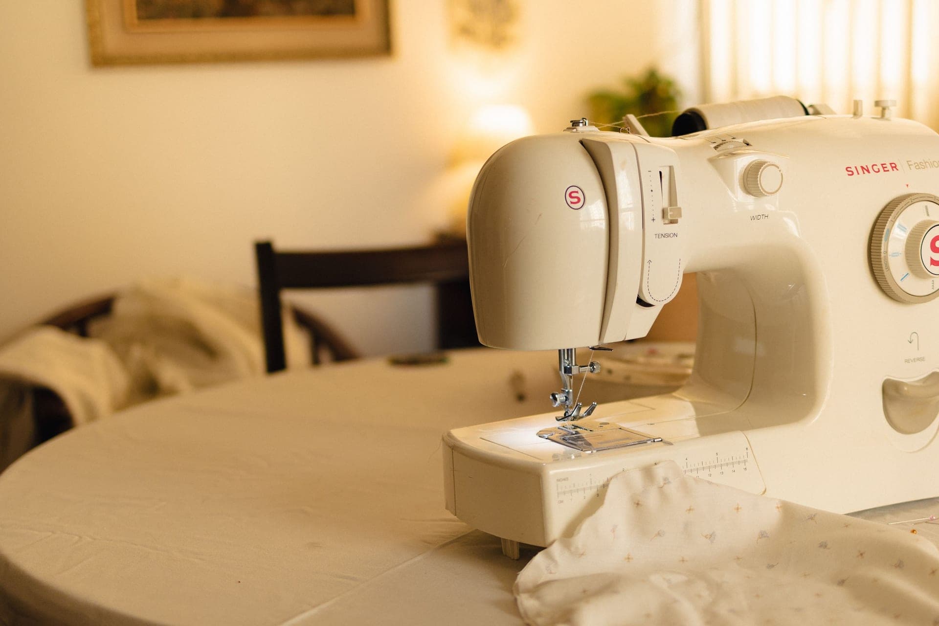 A white sewing machine on a table in soft indoor light