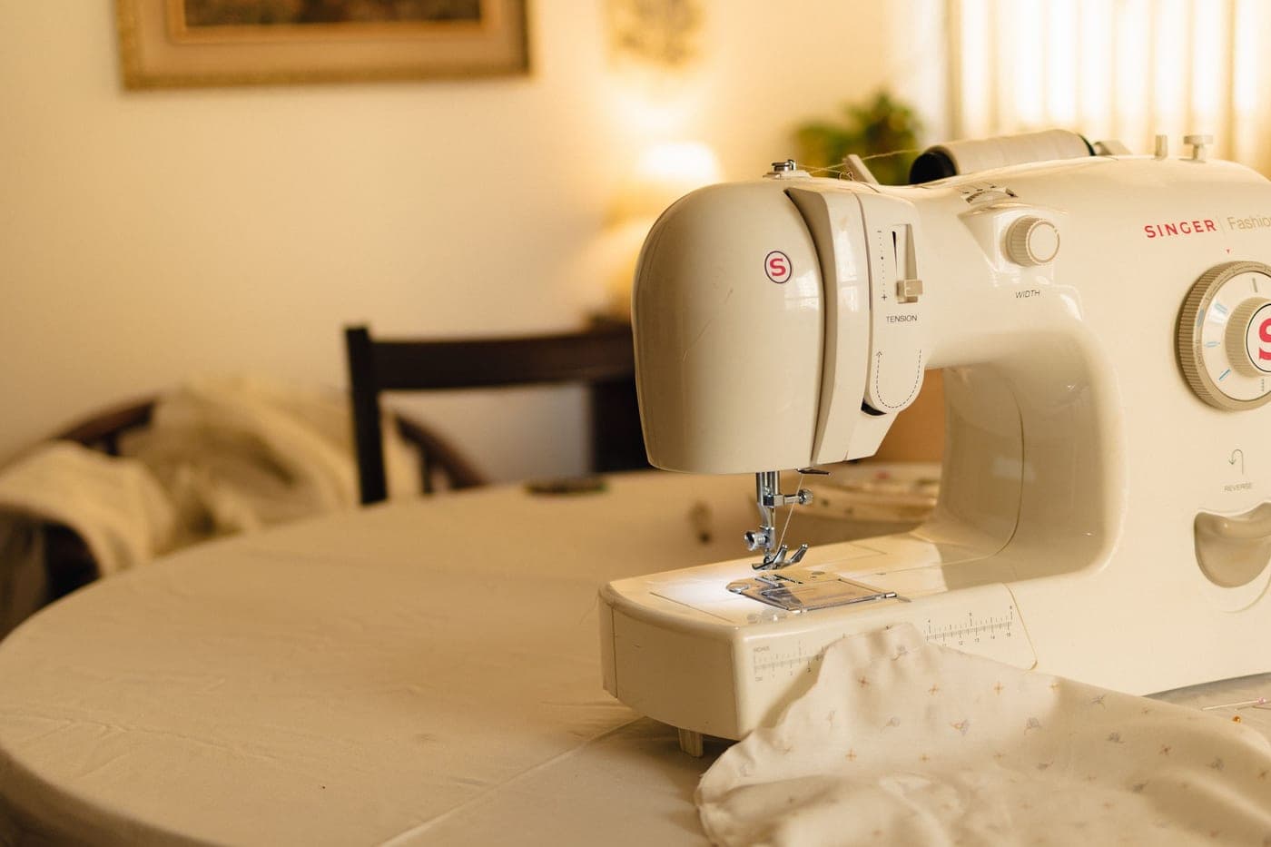 A white sewing machine on a table in soft indoor light