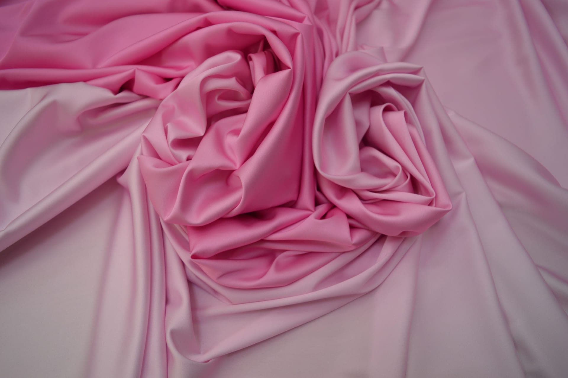 Close view of folded pink satin fabric