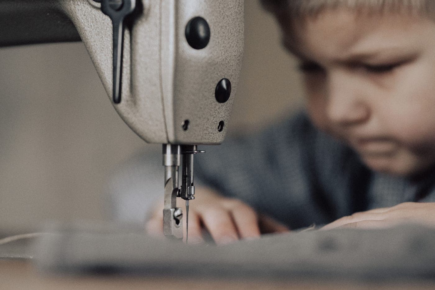 A boy working at a sewing machine