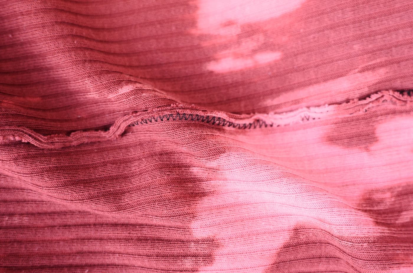 Close view of the inside seam of a pink knit fabric