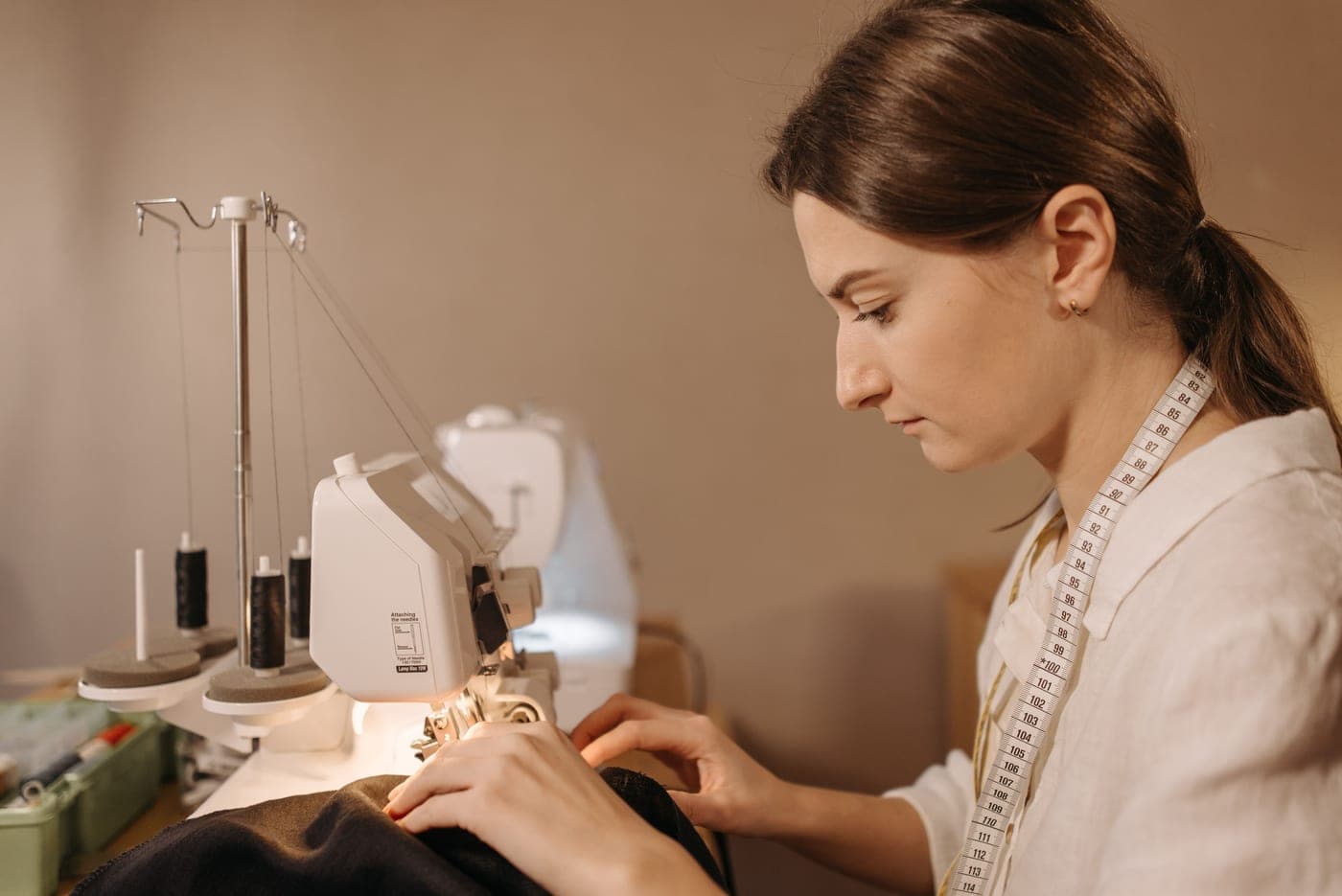 A dressmaker feeding fabric through a sewing machine