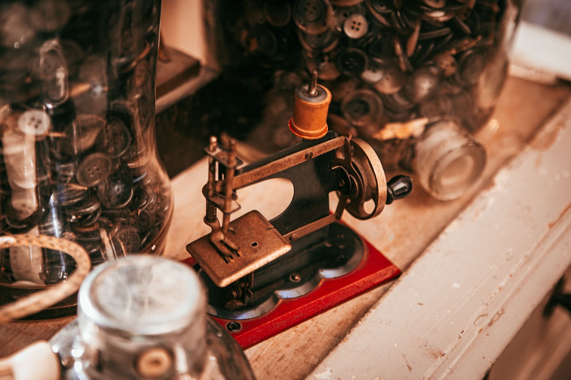 A small metal sewing machine photographed from above on a wooden table