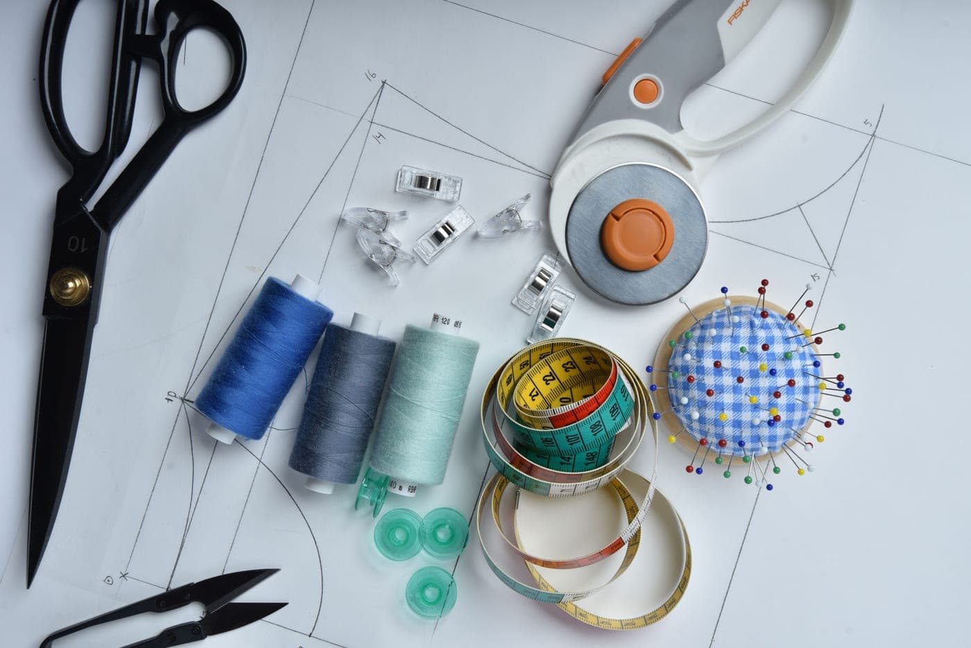 Sewing tools and accessories laid out on pattern paper