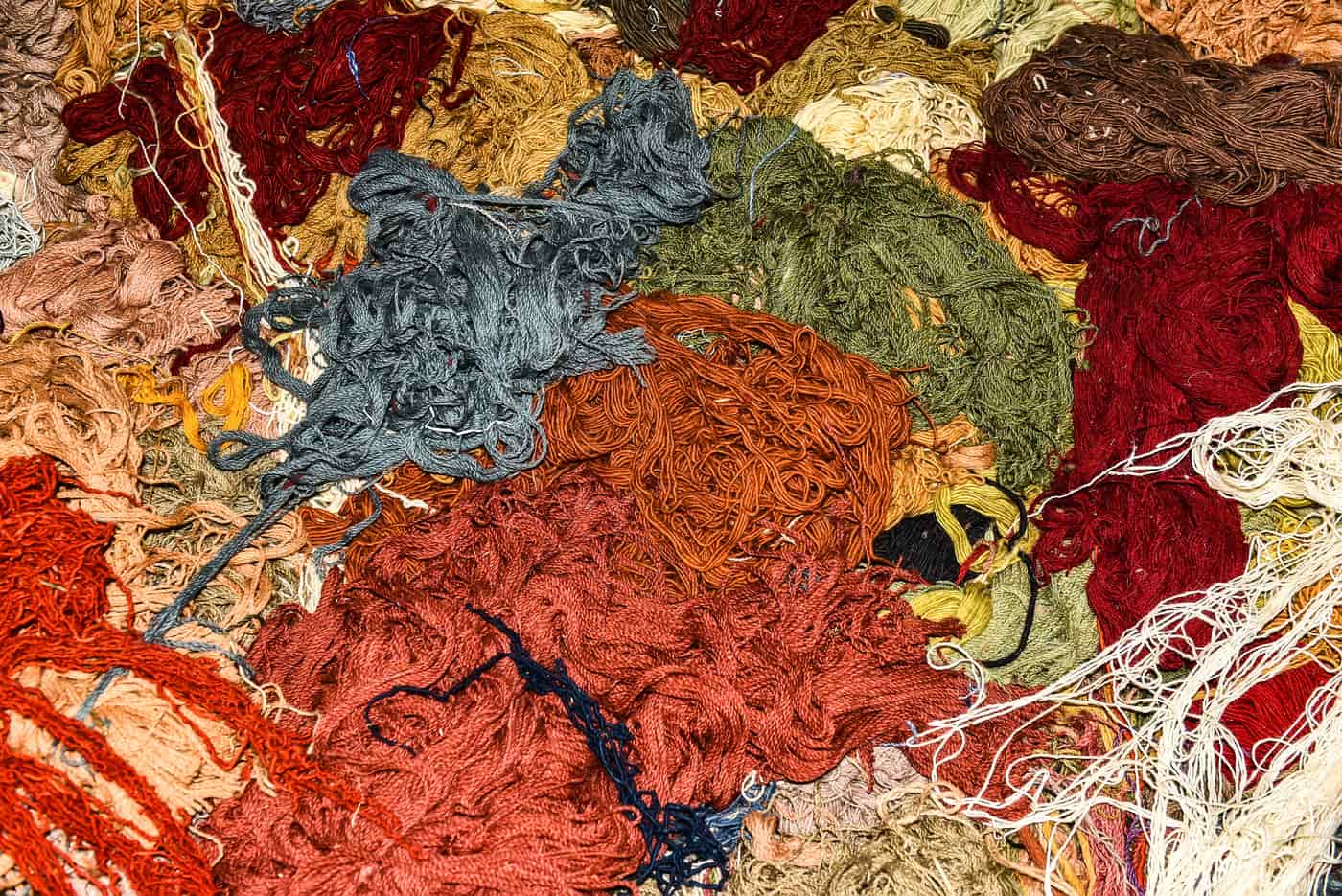 Close view of assorted colored threads in different textures