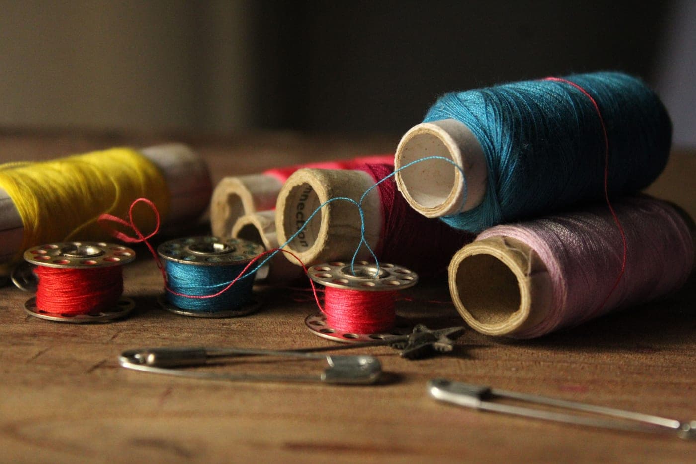 Colorful sewing threads and bobbins on a wooden surface